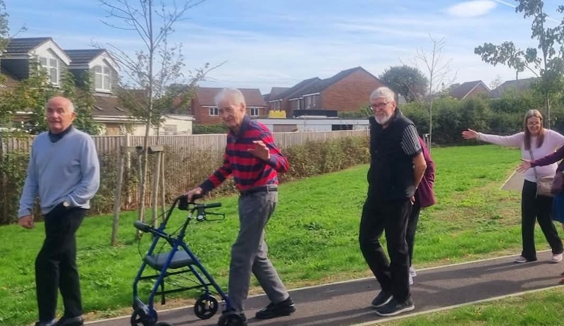 a group of our residents on a walk on a pathway outside