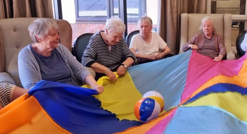 our residents playing with a parachute and blow up balls
